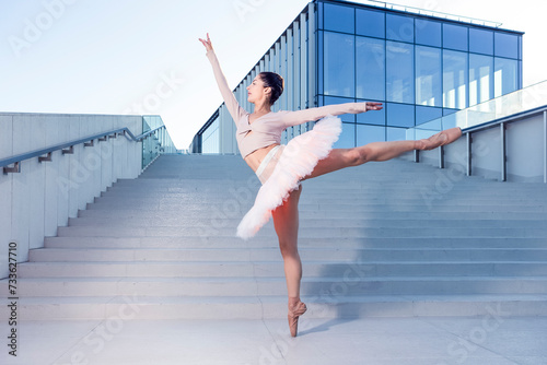 Graceful Slim Professional Caucasian Ballet Dancer in Rose Pink Tutu Dreass Whie Posing In Dance Flying Pose On Blue Stairs