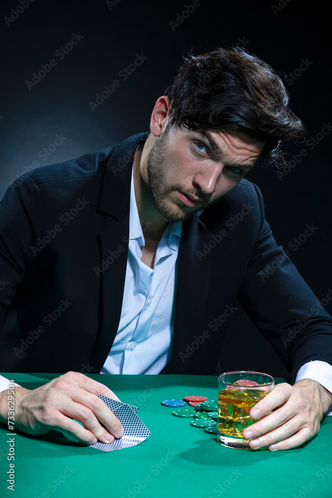 Curious Depressed Handsome Caucasian Brunet Pocker Player At Pocker Table With Chips and Cards Drinking Curious Depressed Handsome Caucasian Brunet Pocker Player At Pocker Table With Chips and Cards Drinking