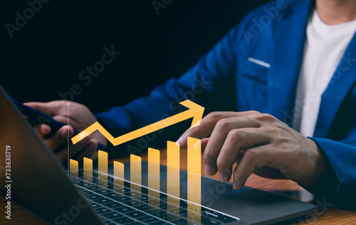 Obraz na płótnie Businessman analyzes company growth using laptop, studying future business growth through arrow graphs. Developing strategies to achieve long-term goals, business outlook, financial data investments. w salonie