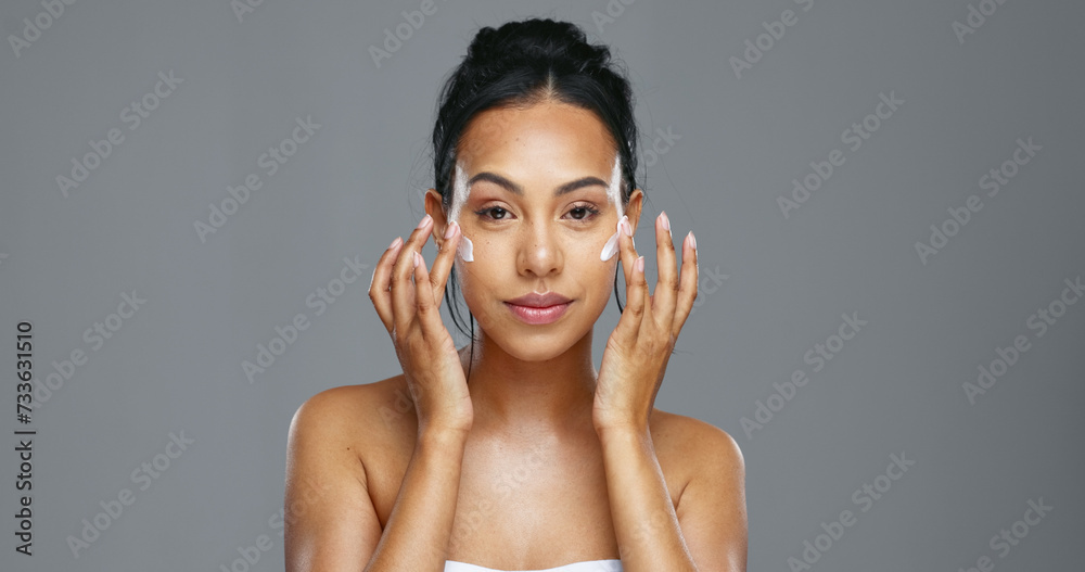 Fototapeta premium Face, skincare and happy woman apply cream in studio isolated on gray background mockup. Portrait, natural beauty and model with moisturizer, cosmetics and product for wellness, dermatology or health
