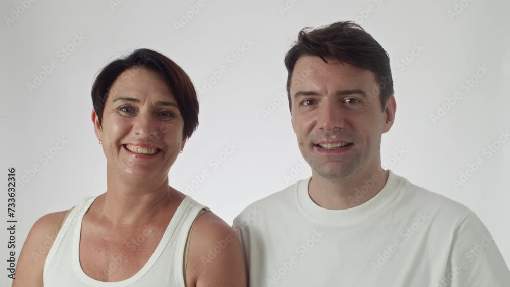Studio portrait of positive middle-aged man and woman smiling at camera on white background Studio portrait of positive middle-aged man and woman smiling at camera on white background