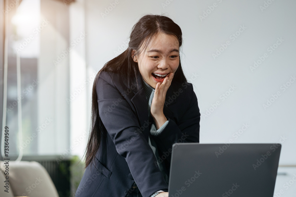 Asian business woman are excited business success with inspiration from their excellent financial results that are happy working in a modern office on a computer.
