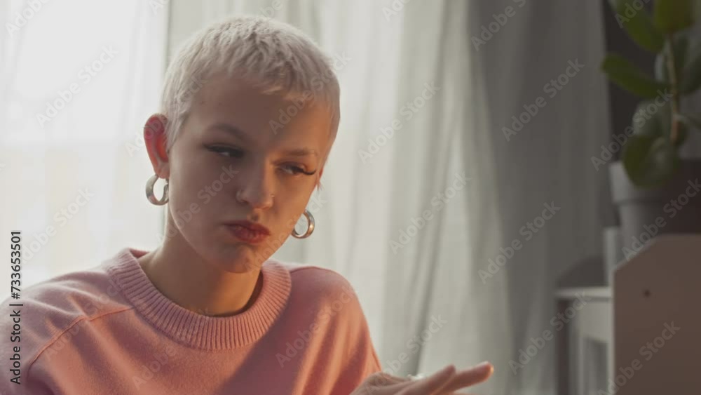 Young Caucasian woman with short blond hair using laptop while having conversation with female colleague with help of sign language Young Caucasian woman with short blond hair using laptop while having conversation with female colleague with help of sign language