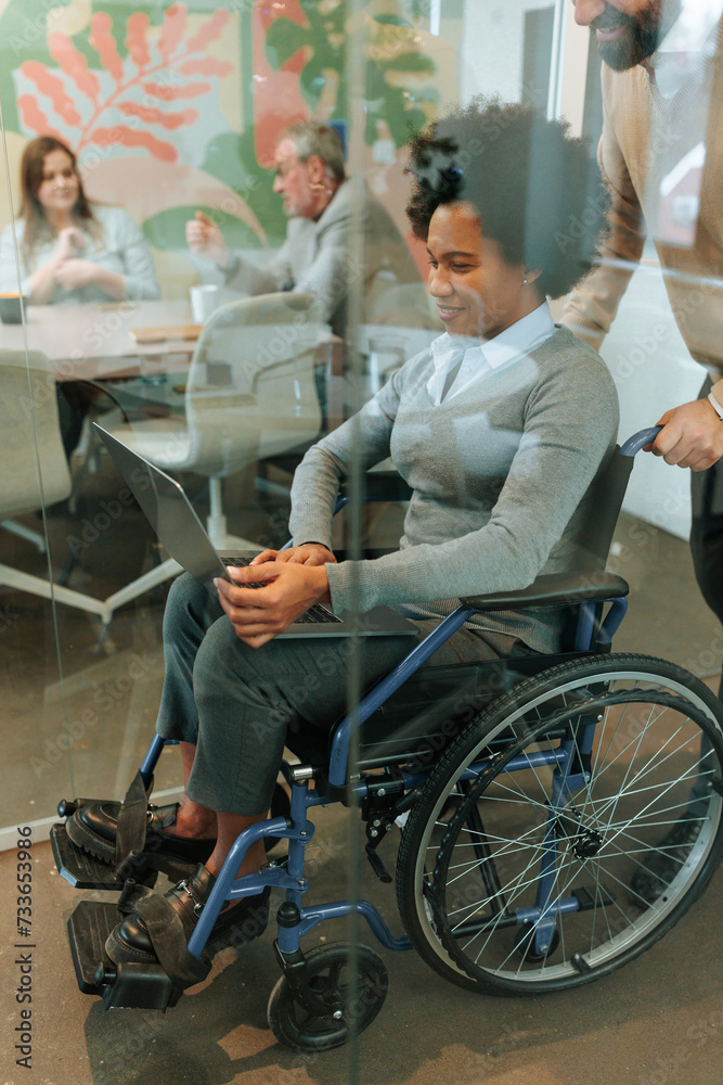 Office worker in a wheelchair working in a conference room Office worker in a wheelchair working in a conference room