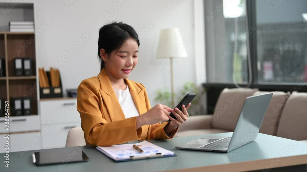 Young beautiful woman using laptop and tablet while sitting at her working place. Concentrated at work. Young beautiful woman using laptop and tablet while sitting at her working place. Concentrated at work.