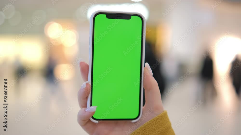 Use green screen for copy space closeup. Chroma key mock-up on smartphone in hand. Woman holds mobile phone and swipes photos or pictures in the mall 4K Use green screen for copy space closeup. Chroma key mock-up on smartphone in hand. Woman holds mobile phone and swipes photos or pictures in the mall 4K