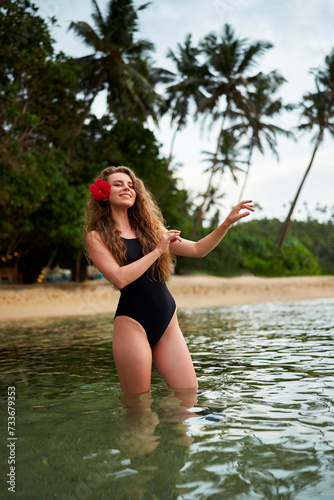 Woman performs hula dance in sea, tropical backdrop, flower in hair, travel, Hawaiian culture, serene beach holiday, relax. Cultural dance expression, ocean waves, tourism attraction, summer getaway.