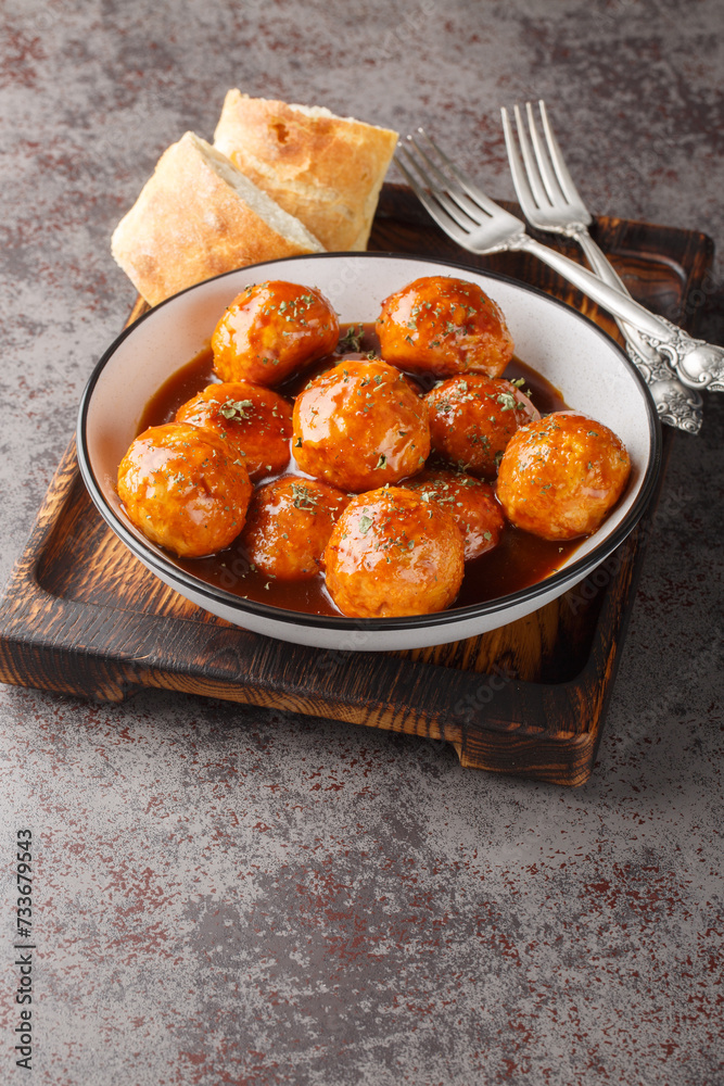 Chicken meatballs in honey glaze and spicy sauce close-up in a bowl on the table. Vertical Chicken meatballs in honey glaze and spicy sauce close-up in a bowl on the table. Vertical
