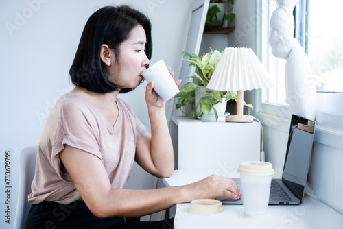 Fotografi caffeine addiction concept with Asian woman drinking too much coffee while worki