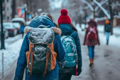Teenagers With Backpacks Walking To School In Winter, Seen From Behind