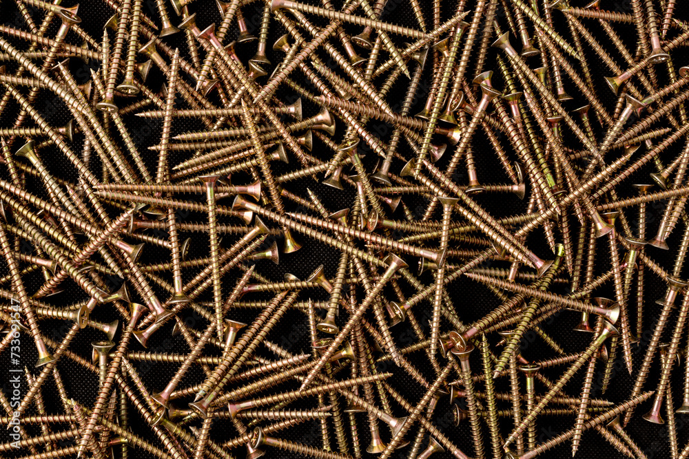 Steel self-tapping screws on black background, metal screw, iron screw, screws as background, wooden screws