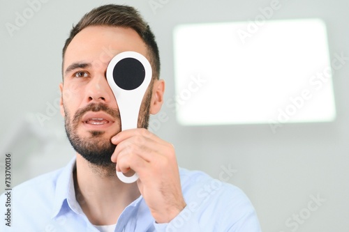 Test of sight. Man is checking his vision indoors in the clinic