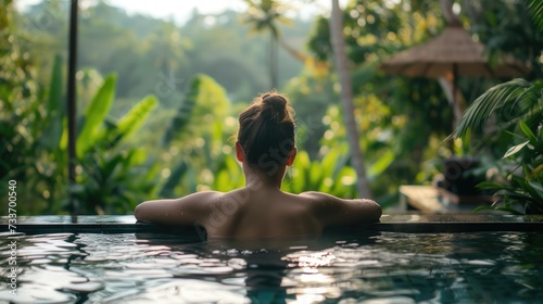 Back View of Poolside Relaxation: Rear view of a person enjoying a peaceful moment at the edge of a serene pool