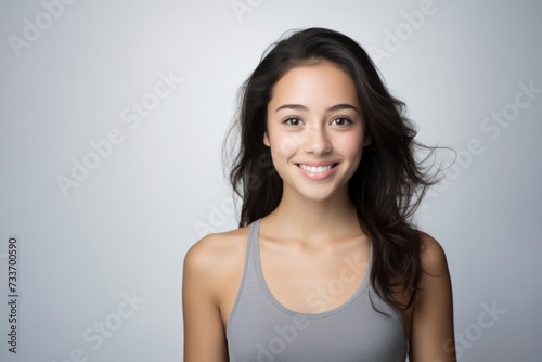 Sweet young girl dressed in comfortable vest undergarments, exuding confidence as she poses gracefully on a pristine white surface. Generative AI.