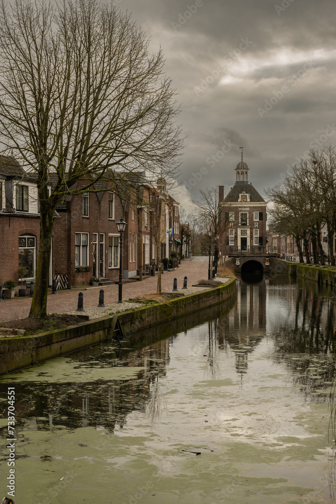 binnenhaven road leading to town hall Stadhuis van Nieuwpoort in historic fortified town on Old Dutch Waterline on cloudy stormy day. old building and bridge reflection in city canal binnenhaven road leading to town hall Stadhuis van Nieuwpoort in historic fortified town on Old Dutch Waterline on cloudy stormy day. old building and bridge reflection in city canal