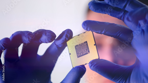 The scientist works in a modern scientific laboratory for the research and development of microelectronics and processors. Microprocessor manufacturing worker uses computer technology and equipment.