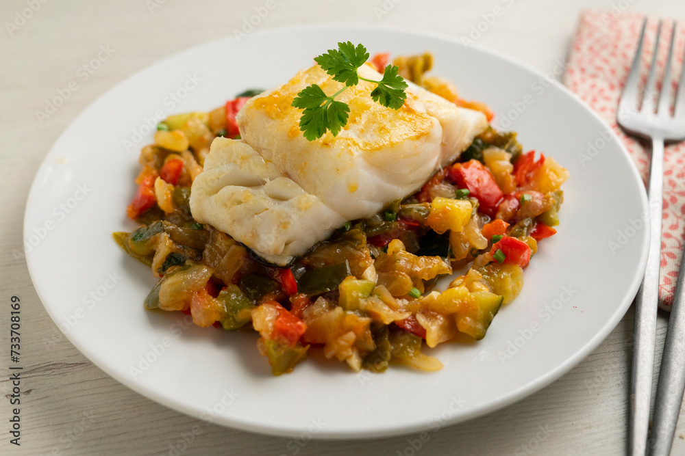 Cod tapa cooked with vegetables in samfaina. Traditional recipe of Spanish gastronomy. Cod tapa cooked with vegetables in samfaina. Traditional recipe of Spanish gastronomy.