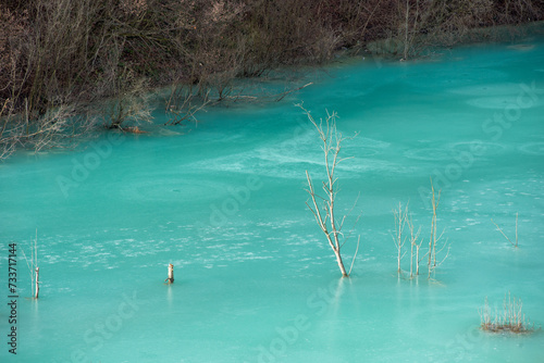 Turquoise waste waters from a copper mine polluting  the environment. Geamana decantation lake, Romania photo