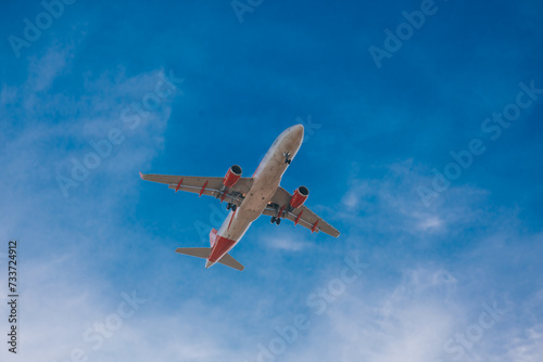 Italy, Milan, San Donato Milanese 14.12.2023. Low flying plane landing at the airport Linate. Airplane against blue sky.