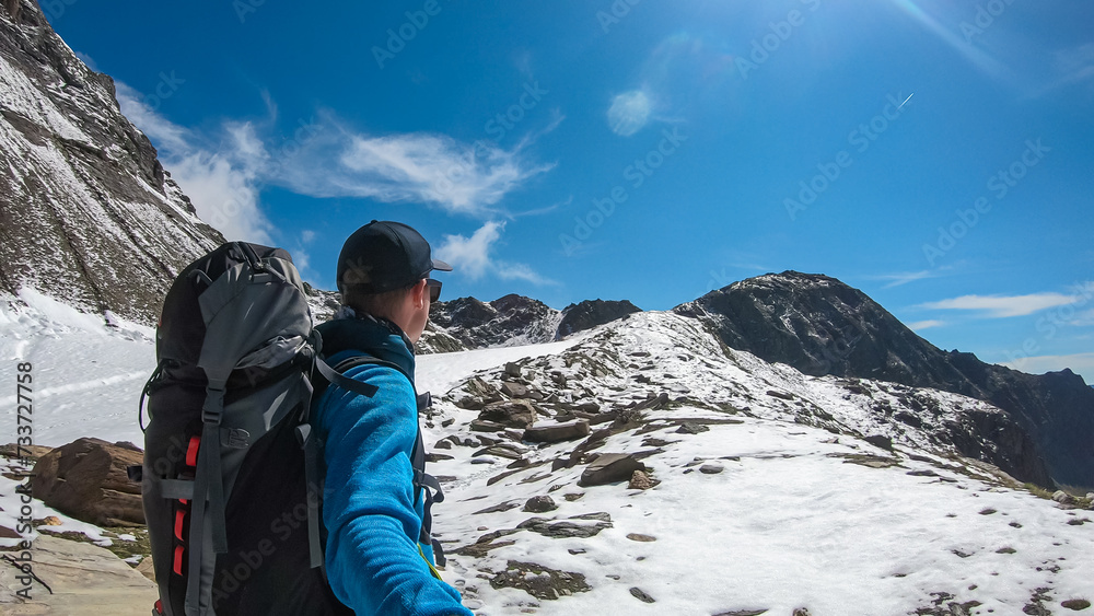 Hiker man with scenic view of majestic mountain peaks of High Tauern near Feldseekopf, Carinthia Salzburg, Austria. Idyllic hiking trail in Goldberg group in wild remote Austrian Alps. Wanderlust