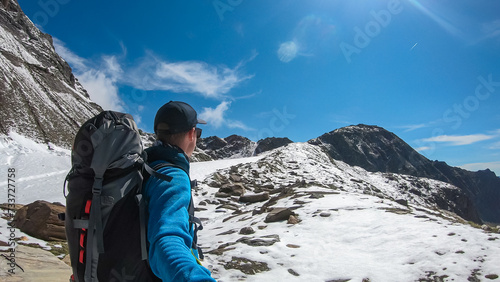 Hiker man with scenic view of majestic mountain peaks of High Tauern near Feldseekopf, Carinthia Salzburg, Austria. Idyllic hiking trail in Goldberg group in wild remote Austrian Alps. Wanderlust photo