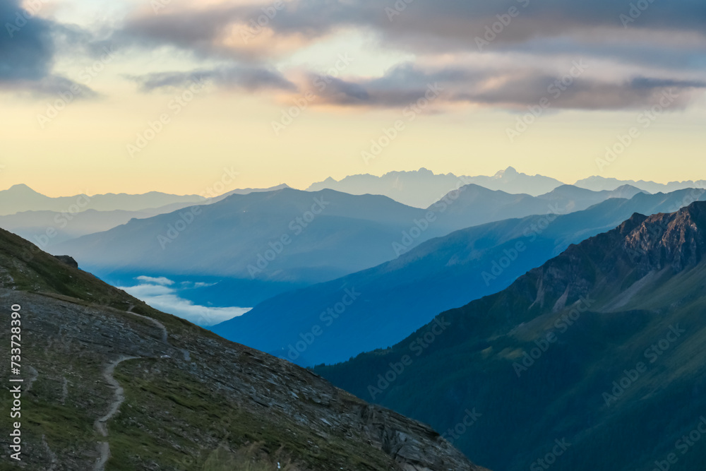 Scenic sunrise view of majestic mountain peaks of remote High Tauern, Carinthia Salzburg, Austria. Idyllic hiking trail of Goldberg group in wilderness of Austrian Alps. Silhouette of hills and ridges