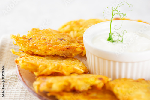 Latkes, levivot, potato pancakes, draniki with sour cream and green, closeup. Hanukkah food. During the Jewish Festival of Lights holiday. photo