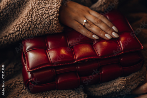 Milan, Italy - December, 17, 2023 Woman wears leather red mini Bottega Veneta Cassette bag, street style details. photo