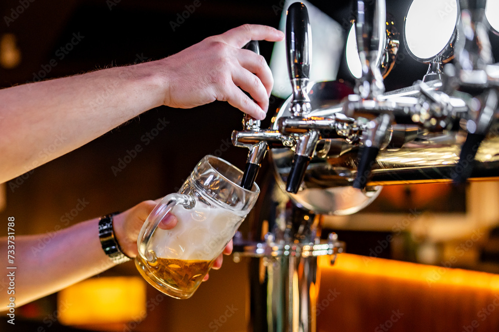man bartender hand at beer tap pouring beer in glass in bar or pub man bartender hand at beer tap pouring beer in glass in bar or pub