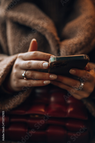 Enjoying travel concept. Young pretty woman tourist traveling by the train sitting near the window using smartphone. Woman using in hands mobile phone close up