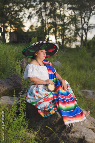 Woman with Mexican hat in rural scenery. Cinco de Mayo celebration in Mexico.