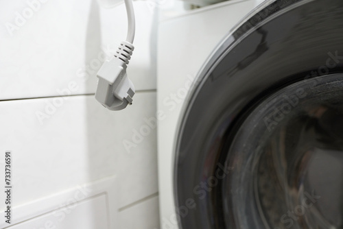 Washing machine with a plug in the bathroom, close-up