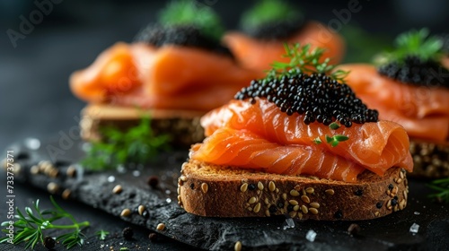 Delicious black caviar sandwiches with salmon on a black background