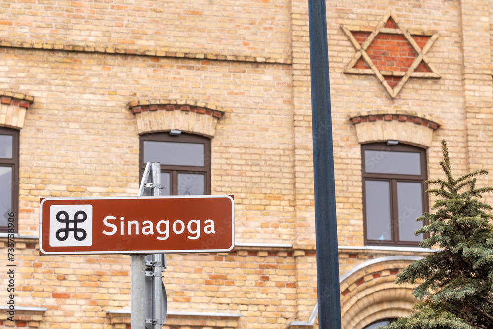 Old brick Synagogue, Jewish shul or temple with road signpost and David star on the facade in Alytus, Lithuania Old brick Synagogue, Jewish shul or temple with road signpost and David star on the facade in Alytus, Lithuania