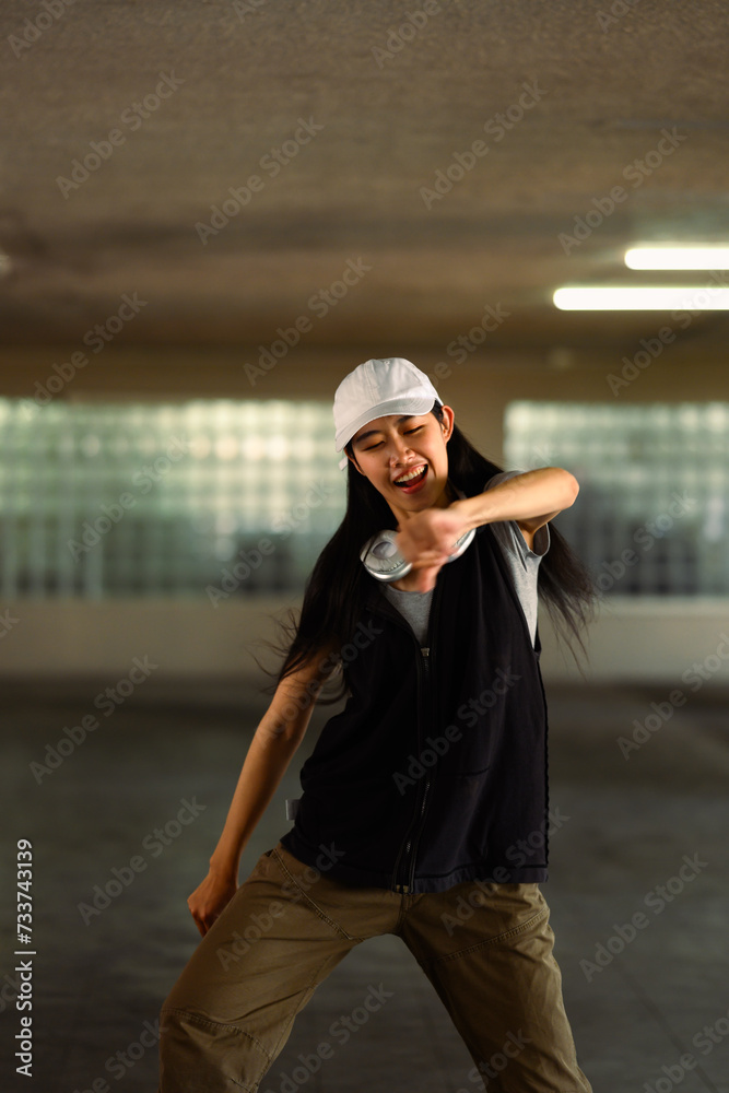 Cheerful young woman performing a Hip Hop dance in parking garage