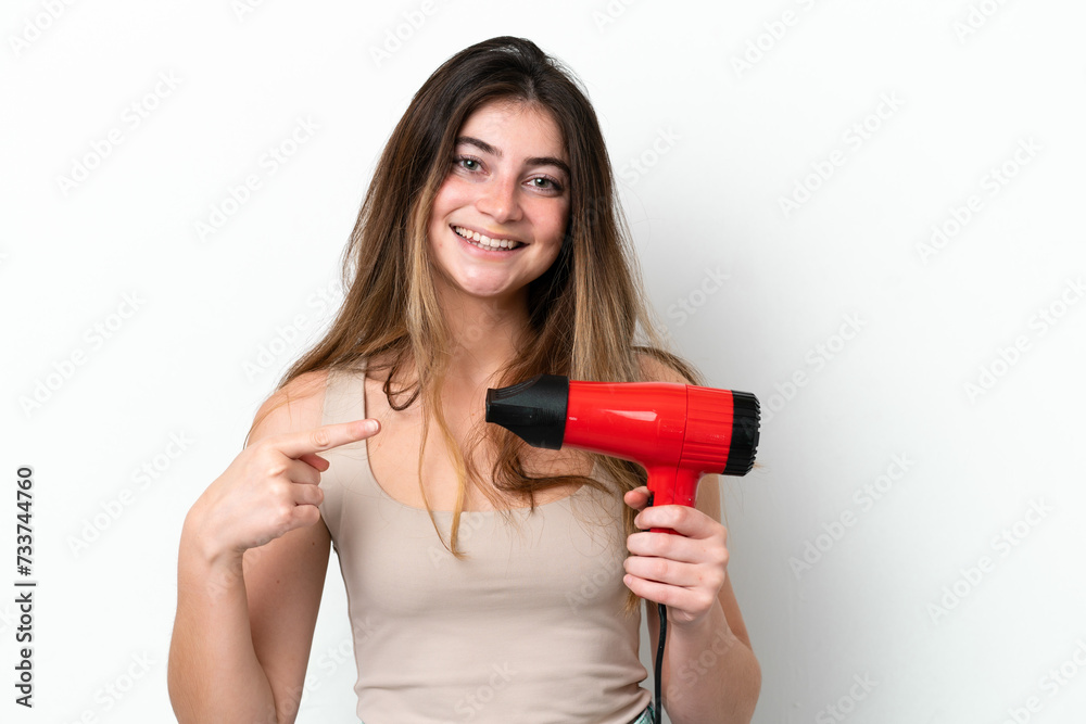 Young caucasian woman holding a hairdryer isolated on white background and pointing it Young caucasian woman holding a hairdryer isolated on white background and pointing it