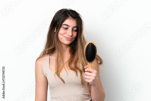 Young woman with hair comb isolated on white background with sad expression