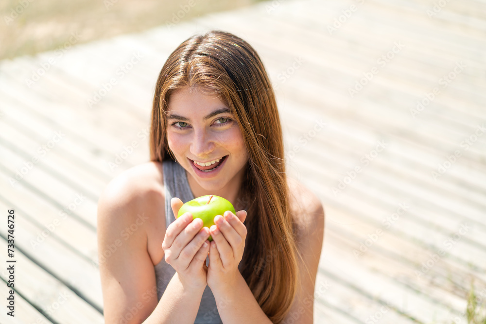 Young pretty caucasian woman holding an apple with happy expression Young pretty caucasian woman holding an apple with happy expression