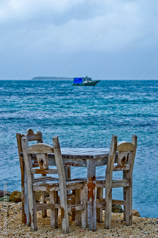 wooden chair on the beach and boat 