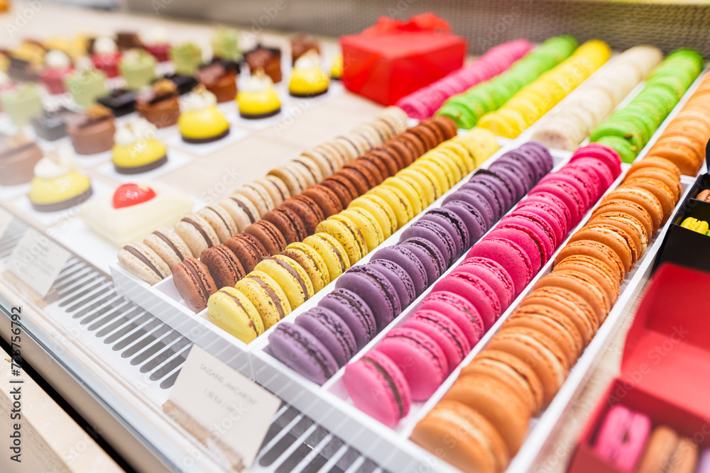 Close-up view of colorful macarons and other sweets on counter display in a bakery Close-up view of colorful macarons and other sweets on counter display in a bakery