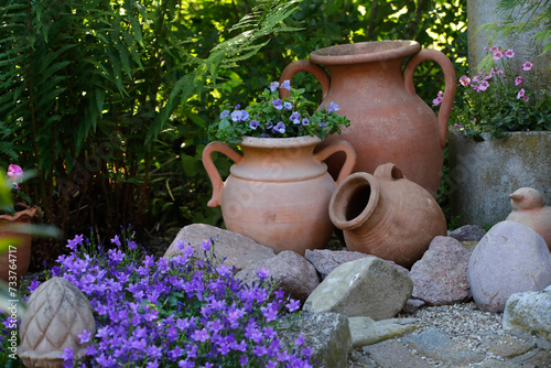 Glockenblumen und Terrakotta Krüge als Deko im Garten 