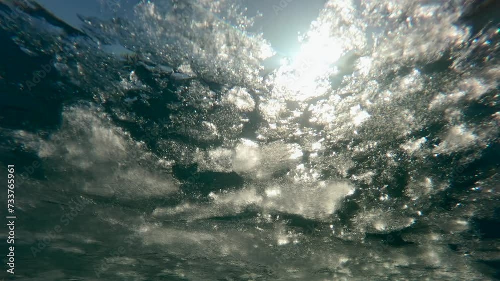Movement of melting spring ice down the river in sun's rays at sunset, Underwater view, Slow motion. Evening sun light penetrates the underwater during ice drift. Movement of melting spring ice down the river in sun's rays at sunset, Underwater view, Slow motion. Evening sun light penetrates the underwater during ice drift.