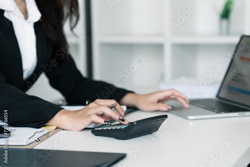 Fototapeta Naklejka Na Ścianę i Meble -  Female accountant working about financial with calculator at her office, Savings, Finances and economy concept