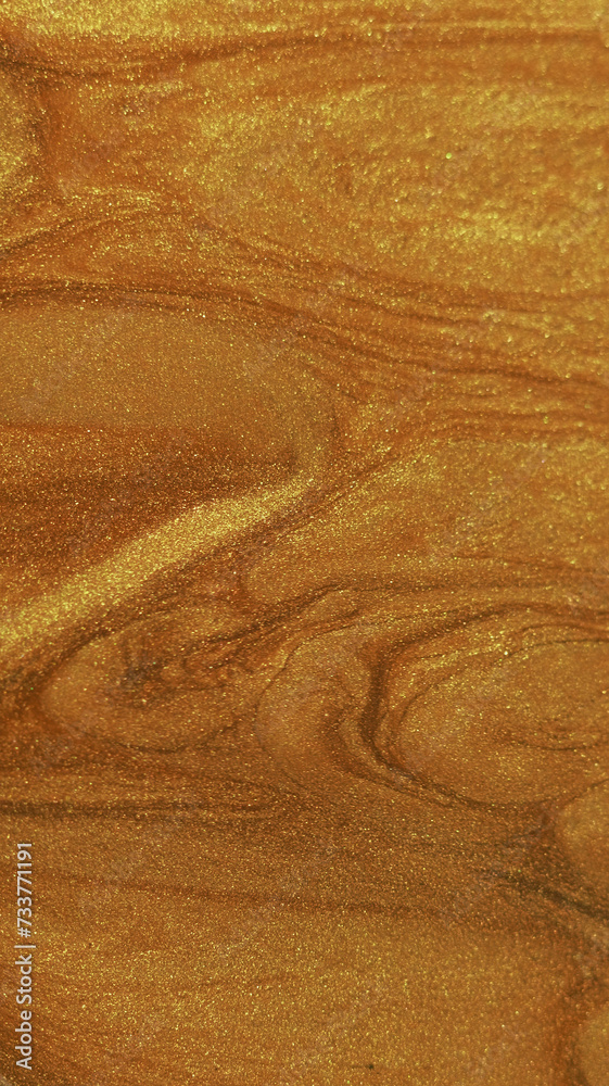 Wet glitter drip. Shimmering texture. Defocused golden color sparkling paint fluid pouring flow reveal motion luxury abstract art background.