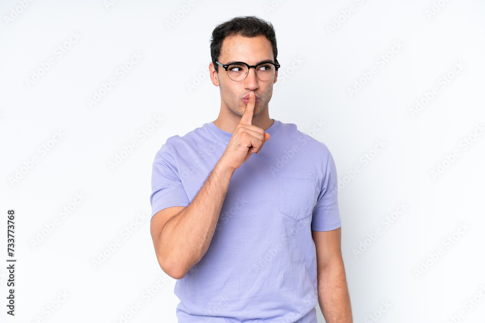 Young caucasian man isolated on white background showing a sign of silence gesture putting finger in mouth