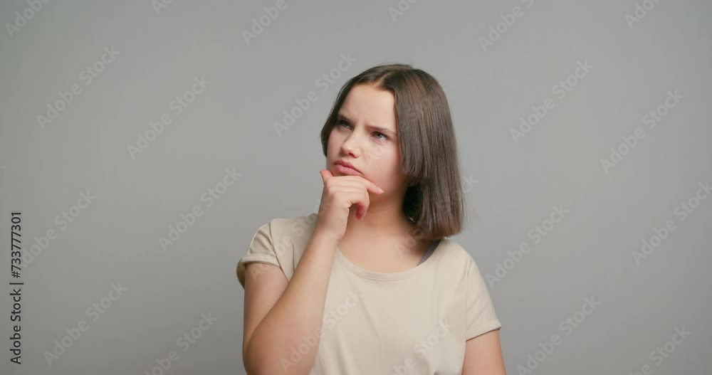 Amazing short hairdo latin teenager looking up empty space deep thinking creative person and coming with idea isolated over gray background Amazing short hairdo latin teenager looking up empty space deep thinking creative person and coming with idea isolated over gray background