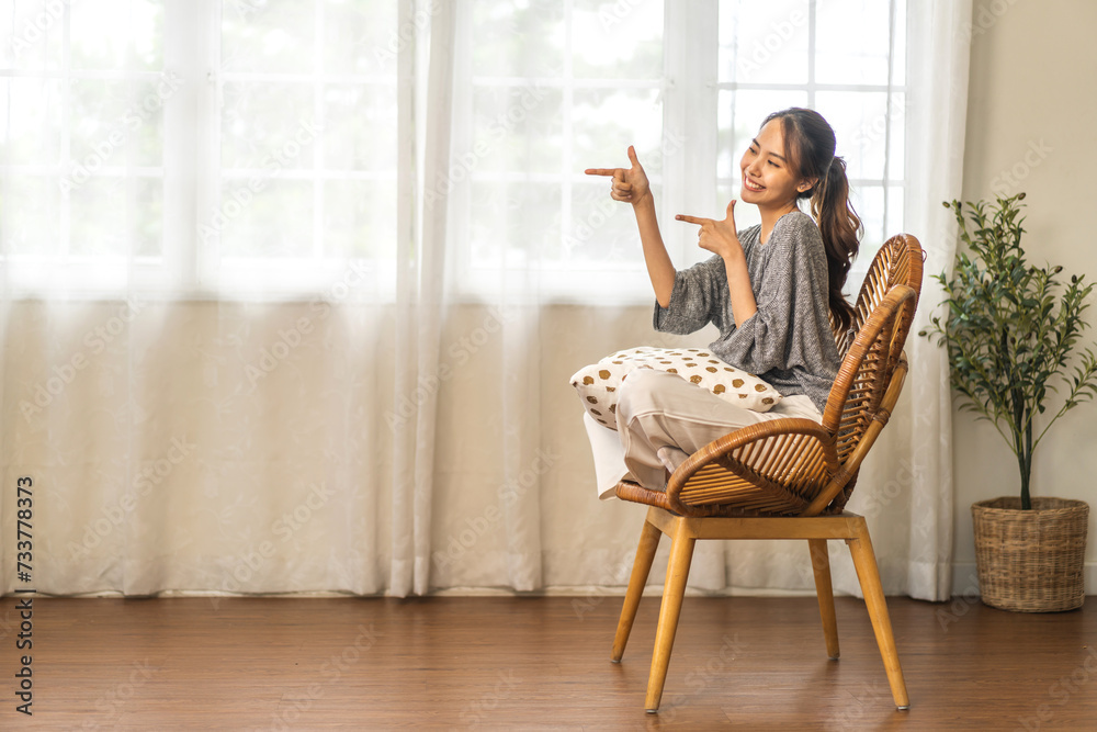Portrait of smiling happy and relax beauty asian woman pointing finger on banner copyspace for advertising and introduce new product, customer, recommend, positive, present at home Portrait of smiling happy and relax beauty asian woman pointing finger on banner copyspace for advertising and introduce new product, customer, recommend, positive, present at home