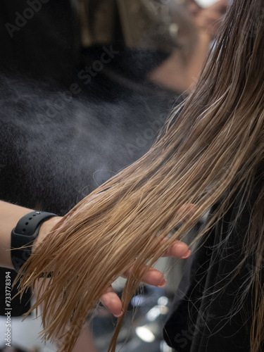 Hairdresser sprays spray on hair