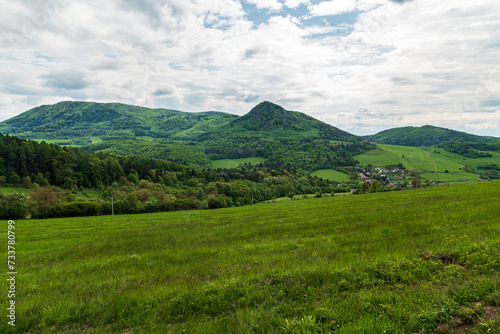 Huge fresh green meadow, small village and mostly forest covered hills above - beautiful Starzovske vrchy mountains in Slovakia