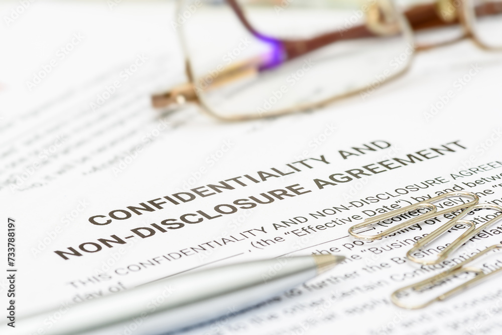 Blue pen on a confidentiality and non-disclosure agreement form. A confidentiality and non-disclosure agreement form safeguards sensitive information, outlining obligations, exceptions, and remedies. Blue pen on a confidentiality and non-disclosure agreement form. A confidentiality and non-disclosure agreement form safeguards sensitive information, outlining obligations, exceptions, and remedies.